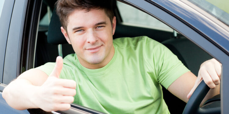 Handsome male driver sitting in a car and smiling